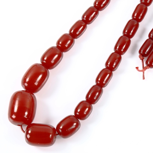 363 - A graduated single-strand cherry red amber barrel bead necklace, bead lengths 26.6mm to 15.2mm, neck... 