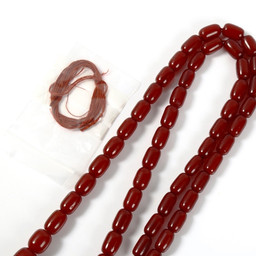 363 - A graduated single-strand cherry red amber barrel bead necklace, bead lengths 26.6mm to 15.2mm, neck... 