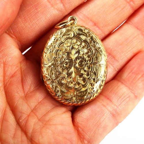 390 - A Victorian 9ct gold oval photo locket pendant, allover engraved floral decoration, pendant height e... 