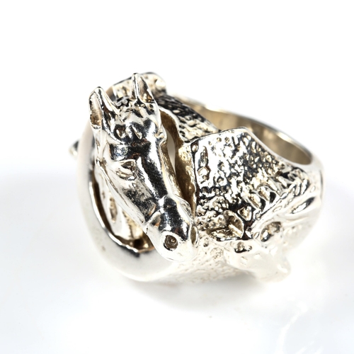 404 - A large and heavy silver horse ring, with horseshoe motif, setting height 31.8mm, size Y, 86.5g