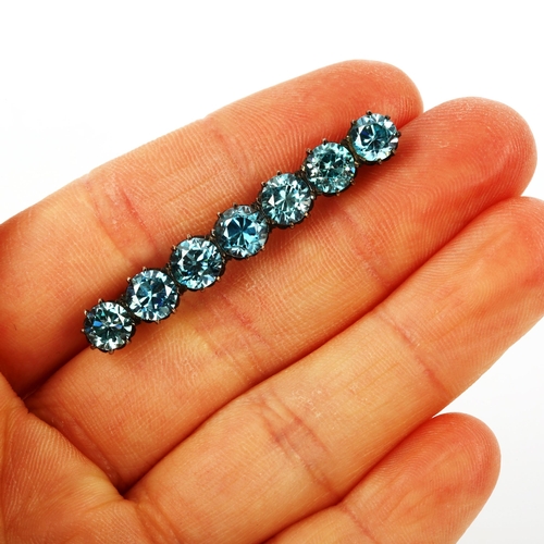 418 - An Art Deco graduated blue zircon matching line bracelet and brooch, largest zircon measures: 8.78mm... 