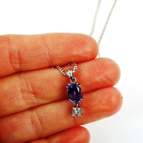 426 - A modern 18ct white gold tanzanite and diamond pendant necklace, set with oval mixed-cut tanzanite a... 