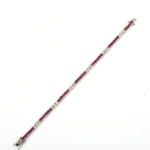 427 - A modern sterling silver ruby and cubic zirconia tennis line bracelet, bracelet length 18cm, 12.4g