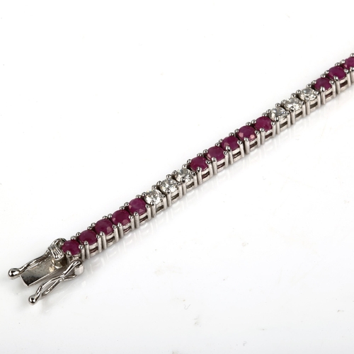 427 - A modern sterling silver ruby and cubic zirconia tennis line bracelet, bracelet length 18cm, 12.4g