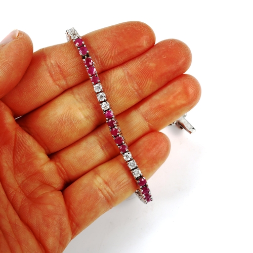 427 - A modern sterling silver ruby and cubic zirconia tennis line bracelet, bracelet length 18cm, 12.4g