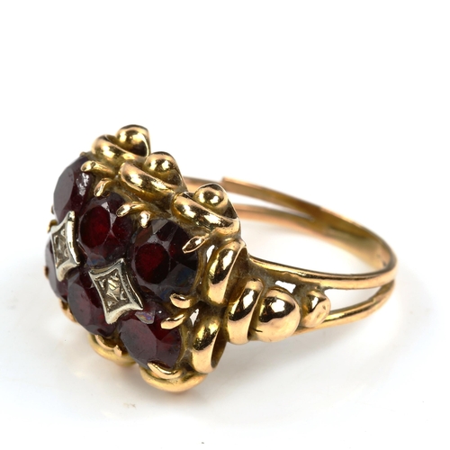 430 - A large unmarked gold garnet dress ring, set with round-cut garnets, setting height 17.3mm, size Q, ... 