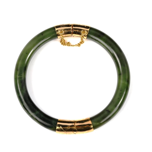 440 - A Chinese jade hinged bangle, with gilt-metal mounts, internal diameter 6cm, 35.3g