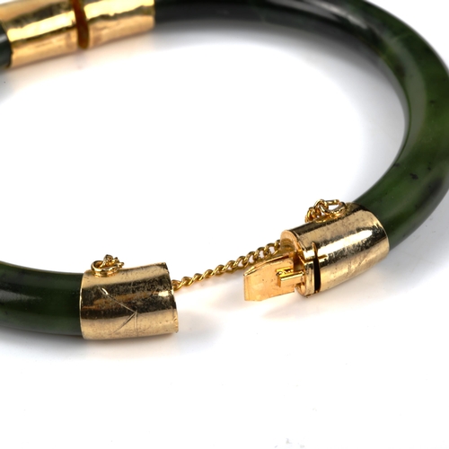 440 - A Chinese jade hinged bangle, with gilt-metal mounts, internal diameter 6cm, 35.3g