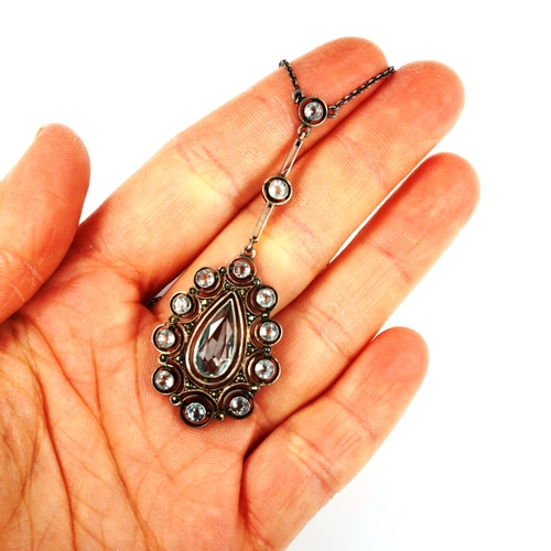 467 - An Art Deco Continental sterling silver and paste openwork pendant necklace, on fine cable link chai... 