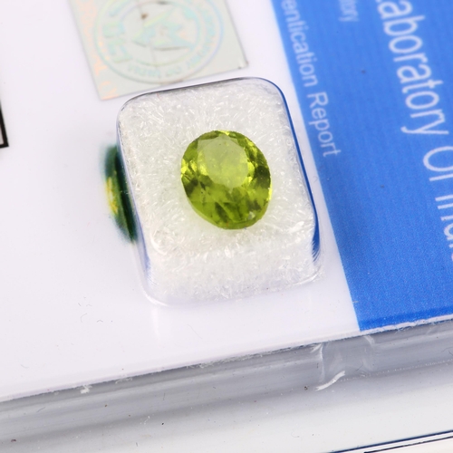 523 - An unmounted 2.3ct oval mixed-cut peridot, 10.40mm x 7.30mm x 4.30mm, with GLI report card