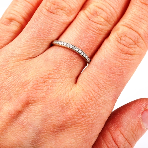 548 - An unmarked white gold diamond half eternity ring, set with modern round brilliant-cut diamonds, ban... 