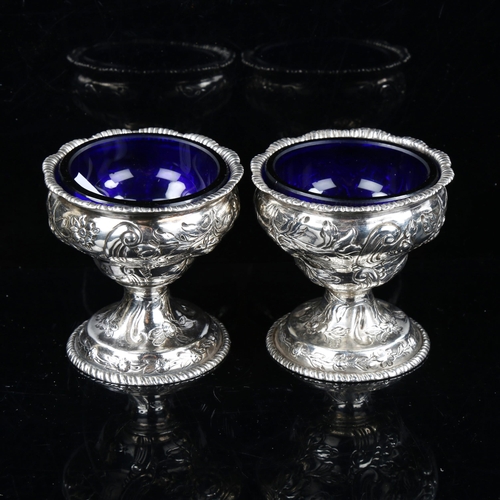 737 - A pair of George III Irish silver pedestal salt cellars, with blue glass liners and relief embossed ... 