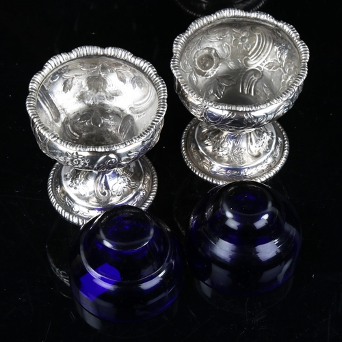 737 - A pair of George III Irish silver pedestal salt cellars, with blue glass liners and relief embossed ... 