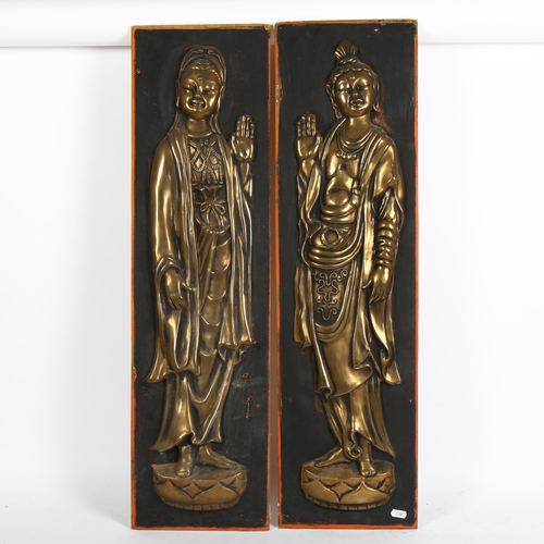 63 - A pair of relief embossed brass figural Buddhist plaques, 84cm x 24cm