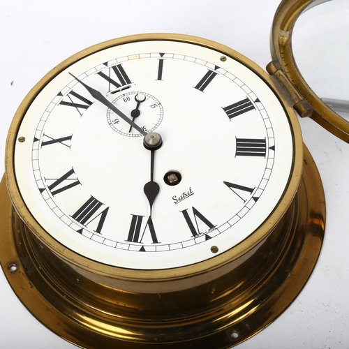 243 - A brass ship's bulkhead clock, by Sestrel, dial diameter 15.5cm, working order, with key