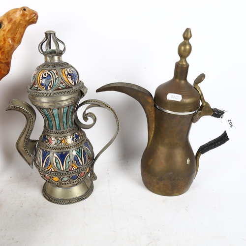 502 - Omani coffee pots, tallest 31cm, a brass hot water jug, a stand, and a leather camel