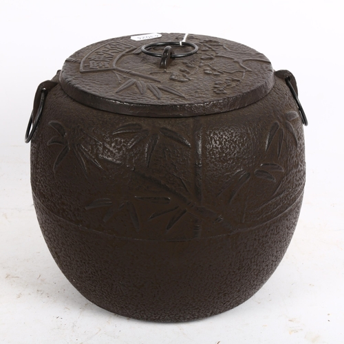 795 - A Chinese cast-iron pot, with embossed decoration, height 19cm