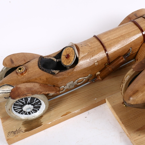 801 - Clive Fredriksson, 2 carved and painted wood veteran car sculptures, on pine plinths, length 47cm