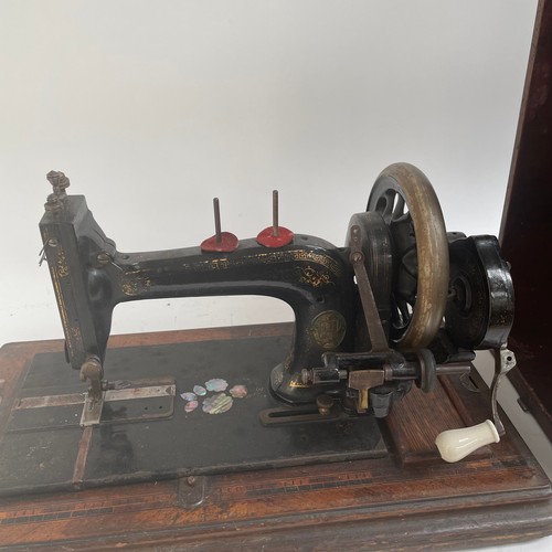 485 - An Antique sewing machine, in inlaid wooden case