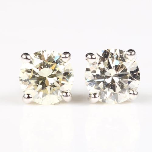 116 - A pair of 18ct white gold 1.01ct solitaire diamond stud earrings, plain 4-claw setting with modern r... 