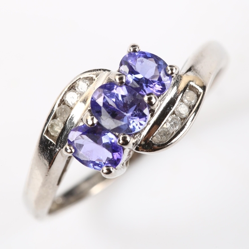 375 - A modern 9ct white gold tanzanite and diamond crossover ring, set with oval mixed-cut tanzanite and ... 