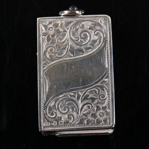 420 - An Edwardian silver Vesta, with spring side panel lid and allover engraved foliate decoration, by Ma... 