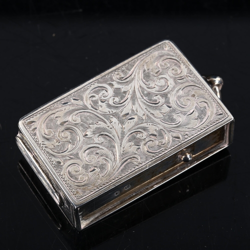 420 - An Edwardian silver Vesta, with spring side panel lid and allover engraved foliate decoration, by Ma... 