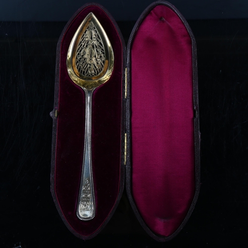 444 - A cased Victorian silver Old English pattern serving spoon, beaded edge with pierced and gilded bowl... 