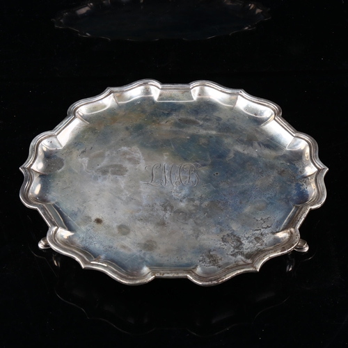 450 - An Edwardian silver salver, circular form with scalloped rim and hoof feet, by Charles Stuart Harris... 