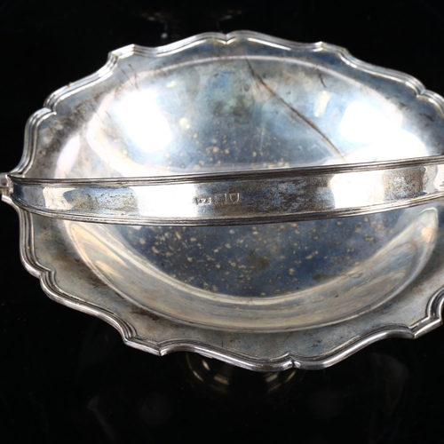 451 - MAPPIN & WEBB - a George V silver swing-handled fruit basket, reeded scalloped rim on pedestal base,... 