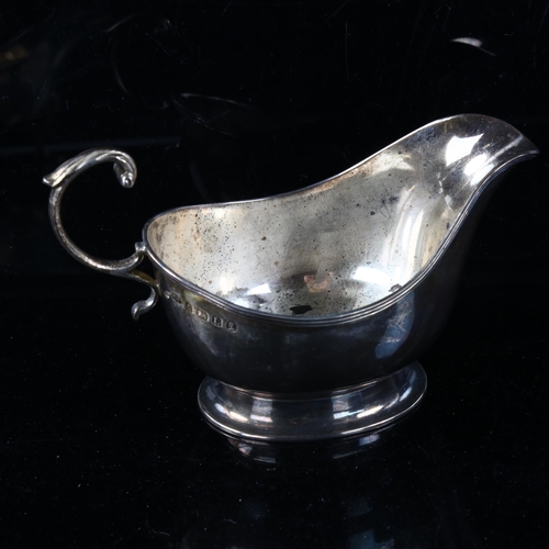 455 - MAPPIN & WEBB - a George V silver sauce boat, pedestal form with reeded rim and a scrolled acanthus ... 