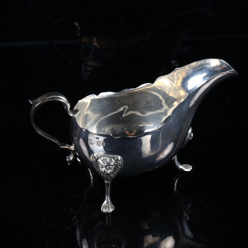 456 - An early 20th century silver sauce boat, with scalloped rim and lion mask feet, by Williams Ltd, ind... 