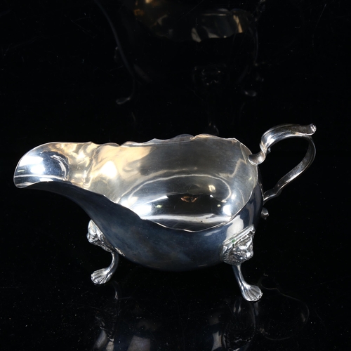 456 - An early 20th century silver sauce boat, with scalloped rim and lion mask feet, by Williams Ltd, ind... 