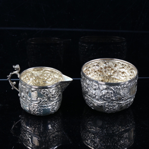 466 - A late Victorian silver matching cream jug and sugar bowl, allover relief embossed floral decoration... 