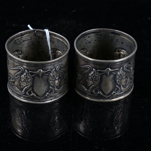 479 - A pair of Art Nouveau Continental silver napkin rings, relief embossed decoration by F Potier, band ... 