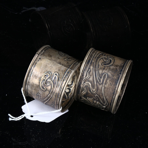 479 - A pair of Art Nouveau Continental silver napkin rings, relief embossed decoration by F Potier, band ... 