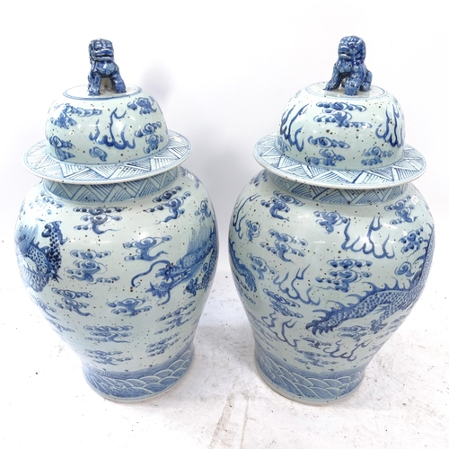 2173 - A large pair of modern Chinese blue and white lidded urns, with dog of fo handle and dragon decorati... 