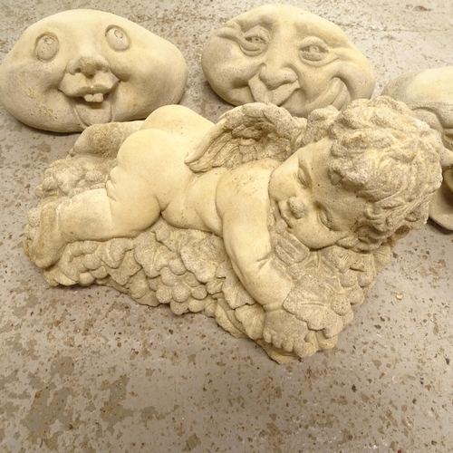 2670 - A small cherub garden ornament, L28cm, and 3 stone faces (4)