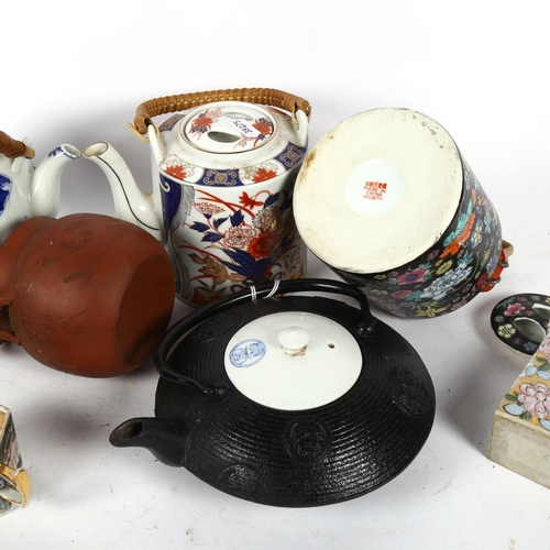 665 - Oriental ceramic tea kettles, and an iron teapot with ceramic lid