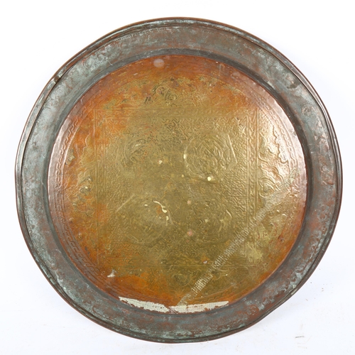 702 - An Islamic silver and copper inlaid brass tray, diameter 33cm