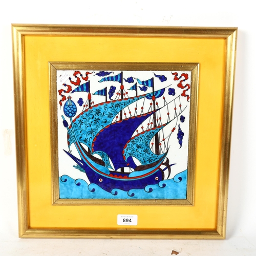 894 - An enamelled tile depicting a sailing ship at sea, framed, height 39cm