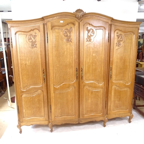 2302 - A French oak bedroom suite, comprising a 4-door armoire with carved shell and acanthus leaf decorati... 