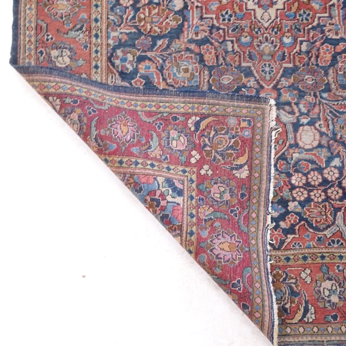 2377 - A red ground wool Kashan rug, 206cm x 135cm