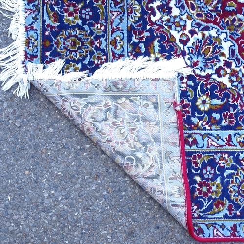 2396 - A modern machine-made red and blue ground Kashmiri carpet, 290cm x 186cm