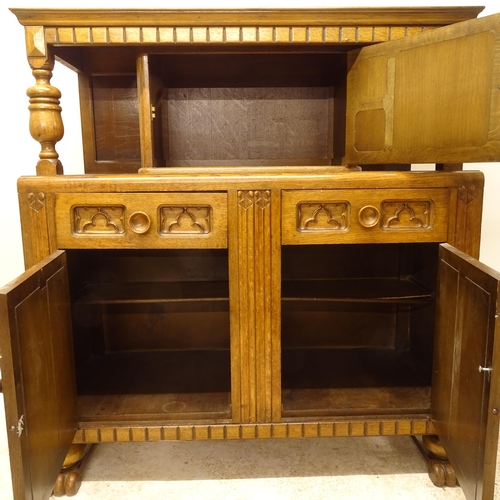 2733 - A 1920s oak court cupboard, with 3 carved and panelled doors, and 2 fitted drawers, W122cm, H135cm, ... 