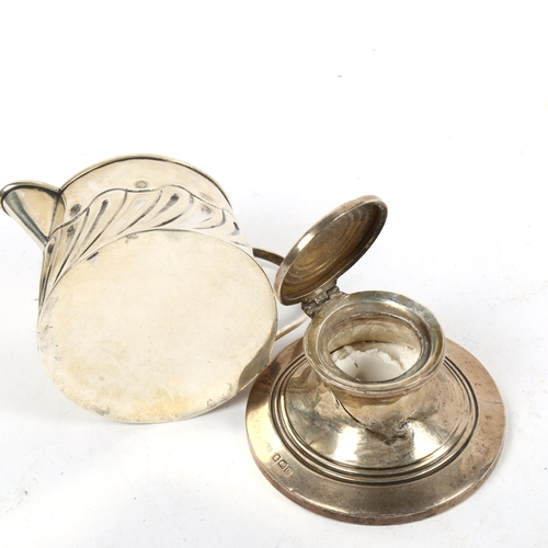 1327 - A small embossed silver cream jug, and a small silver Capstan inkwell (2)