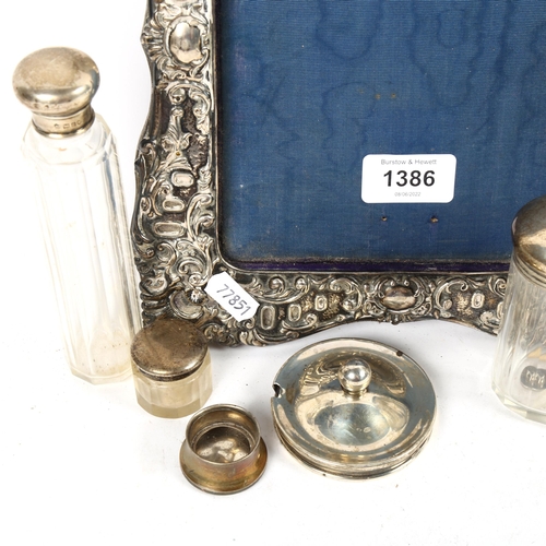 1386 - An embossed and scrolled silver-fronted picture frame (missing strut), and 3 silver-topped dressing ... 