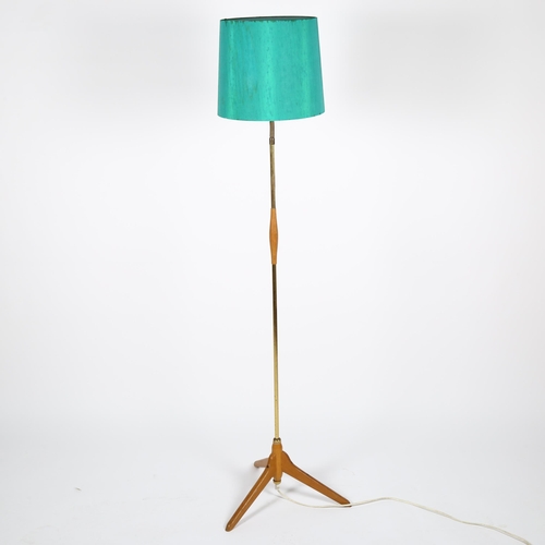 1676 - ORSJO Lighting, a 1950s' oak and brass standard lamp, with adjustable top and original shade, height... 