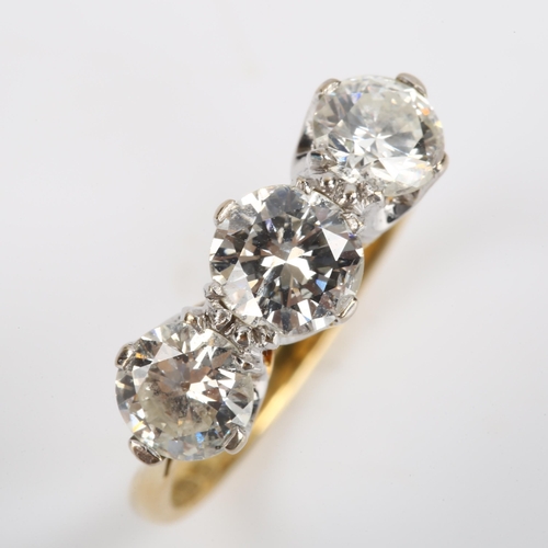 70 - A late 20th century 18ct gold three stone diamond ring, plain claw-set with modern round brilliant-c... 