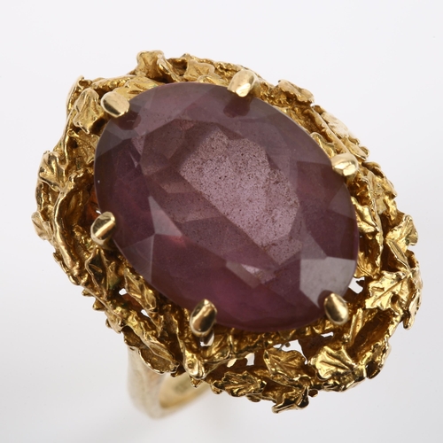 295 - A 1970s 9ct gold amethyst abstract ring, with naturalistic leaf surround and oval mixed-cut amethyst... 